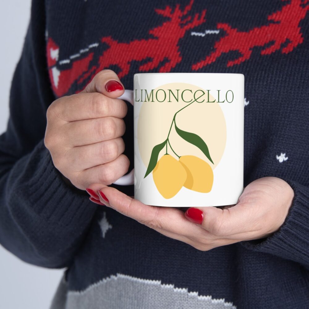 An image of the Custom Logo Ceramic Mug product with a lemon logo. A person is holding the product in their hand.