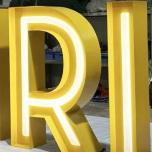 Open Face Channel Letters in yellow stainless steel with neon paint. R and I letters illuminated with warm white LEDs